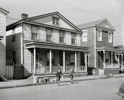 March 1941. "Houses near Navy yard. Portsmouth, Virginia." On garbage day, when there's always a plentiful supply of pucks. Acetate negative by John Vachon. View full size.