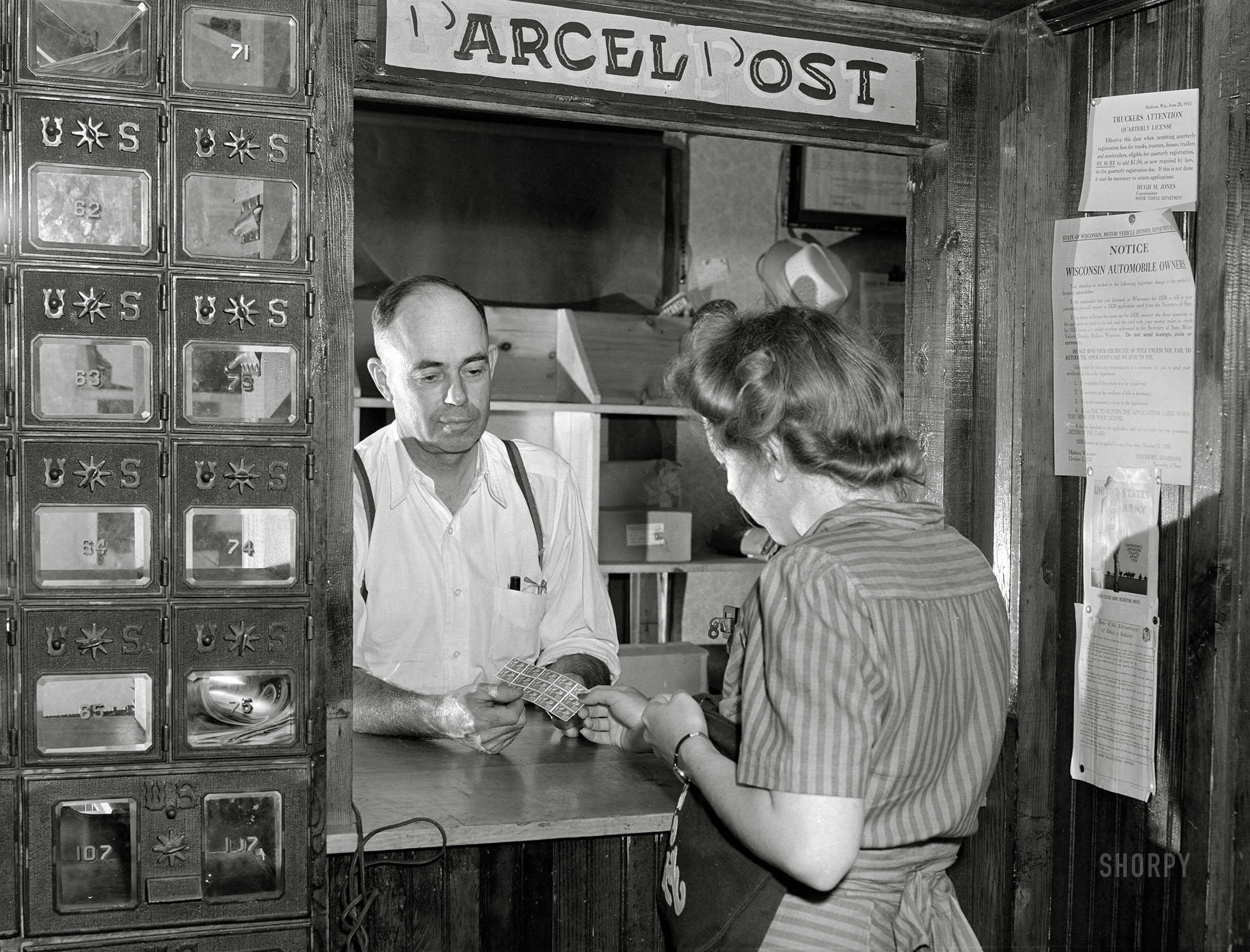 July 1941. "Buying stamps in post office. Siren, Wisconsin." Medium format acetate negative by John Vachon for the Farm Security Administration. View full size.