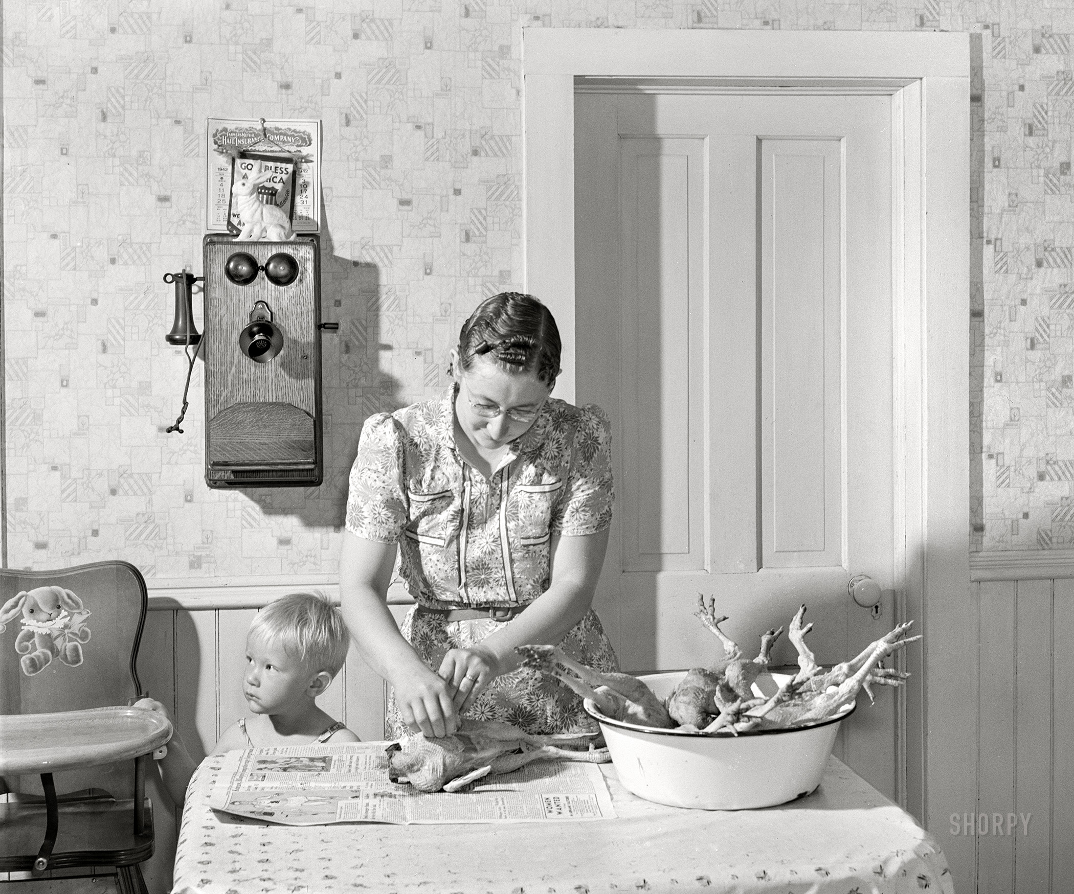 May 1942. "Lancaster County, Nebraska. Mrs. Lynn May, FSA borrower, cleaning a chicken." Acetate negative by John Vachon for the Farm Security Administration. View full size.