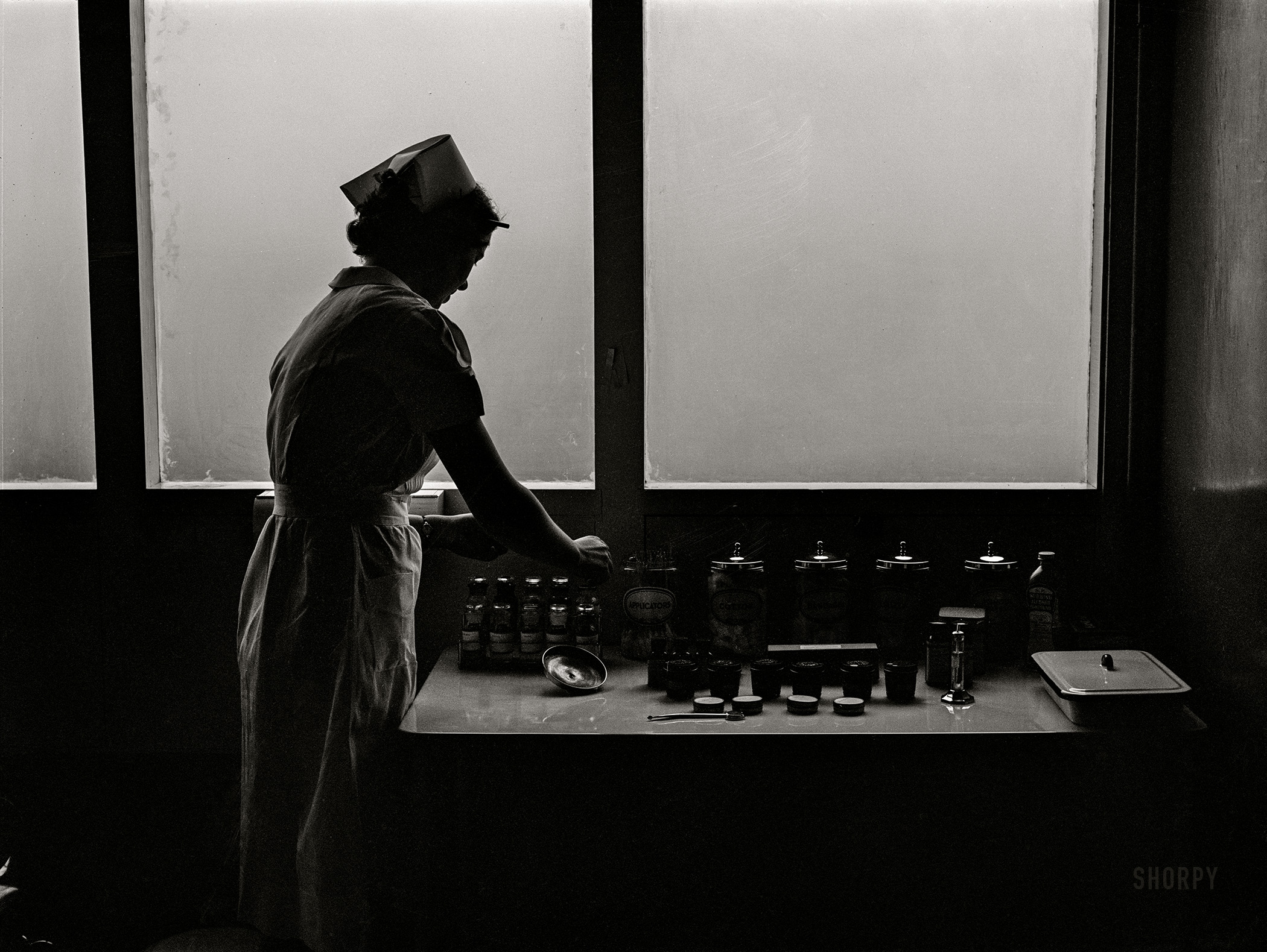 February 1942. Woodville, California. "Nurse at Health Center clinic of FSA farm workers' community." Photo by Russell Lee for the Farm Security Administration. View full size.