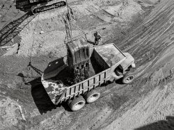 June 1942. "Shasta Dam, Shasta County, California. Steam shovel dumps dirt into dump truck." Acetate negative by Russell Lee for the Office of War Information. View full size.