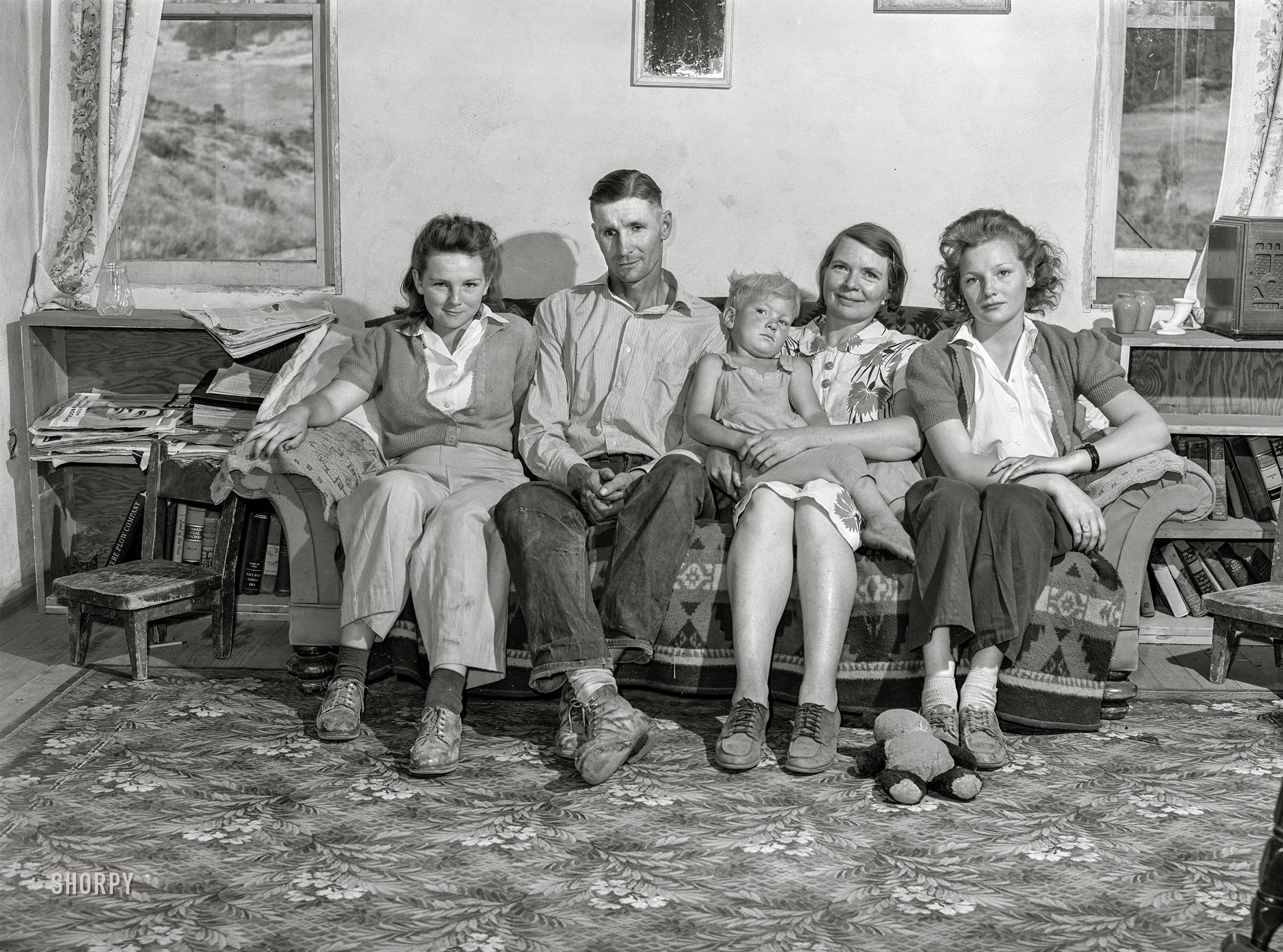 July 1942. "Ola, Idaho. FSA Ola self-help cooperative, adjacent timber stand, sawmill and farms. A member of the cooperative and his family at home. This man is a county commissioner." Photo by Russell Lee for the Farm Security Administration. View full size.