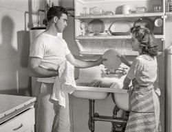May 1942. "Childersburg, Alabama. Cousa Court housing project for defense workers in boom area around the DuPont Powder Plant. The Smiths share the drudgery of housework, for they both have important war jobs." Photo by John Collier, Office of War Information. View full size.