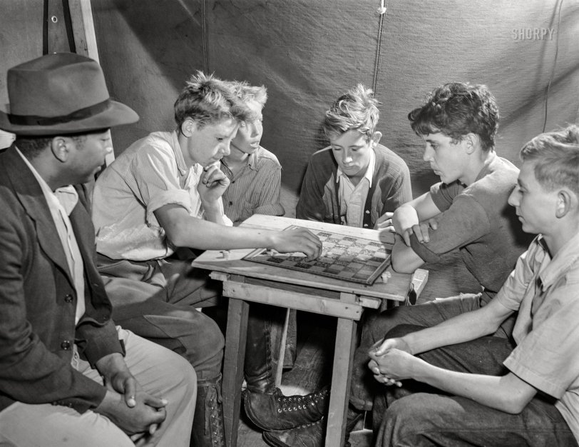 September 1942. Batavia, New York. "Elba FSA farm labor camp. Recreational director watching boys play checkers in recreation tent. They are among voluntary migrant labor from West Virginia and New York City relief rolls arriving in upstate New York to harvest crops." Acetate negative by John Collier for the Farm Security Administration. View full size.
