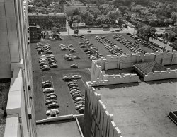 July 1942. "Detroit, Michigan. Looking down on a parking lot from the rear of the Fisher Building." Photo by Arthur Siegel for the Farm Security Administration. View full size.
Nowa Lot more!
All growed upInteresting to look at the size of the "slots" and the actual size of the vehicles parked in them. From when the auto body plant was built til the time of the photo, cars had sure undergone a growth spurt. 
Wonder how that lot made out in the mid-fifties when automobile took a really big jump in size. Perhaps most of all in the creations coming from this very place.
[The Fisher Building is an office tower in downtown Detroit, not an auto body plant. - Dave]

I just thought it was a factory -- my mistake. Is the building named for the same person that ran the design and manufacturing company?
[Did you click on the link? The Fisher family financed the building with proceeds from the sale of Fisher Body to General Motors in the 1920s, after which it was known as the GM Fisher Body Division. - Dave] 
Kid friendlyThe tunnel under West Grand Boulevard, from "The Golden Tower of the Fisher Building" to GM headquarters, where you could see the Soap Box Derby winning cars on display in the lobby.  Or the new models from the General Motors Five.
Like so many other places in '50s Detroit: the Ford Rotunda, J.L. Hudson Co. downtown in December, the little trains at the Detroit Zoo, the Vernor's bottling plant at Woodward and Grand Boulevard, the model railroad layout in the basement of the Detroit Historical Society, the lobby of the Guardian Building, etc.
There was no admission charge for many of these adventures, which fit the family budget nicely.  My father was a shrewd family time investor.
[Strictly speaking, the Ford Rotunda was in Dearborn. - Dave]
A lot of carsIs that what it's called? Like a
school of fish, or a
pride of lions, or a
murder of crows (my favorite).
(The Gallery, Arthur Siegel, Cars, Trucks, Buses, Detroit Photos)