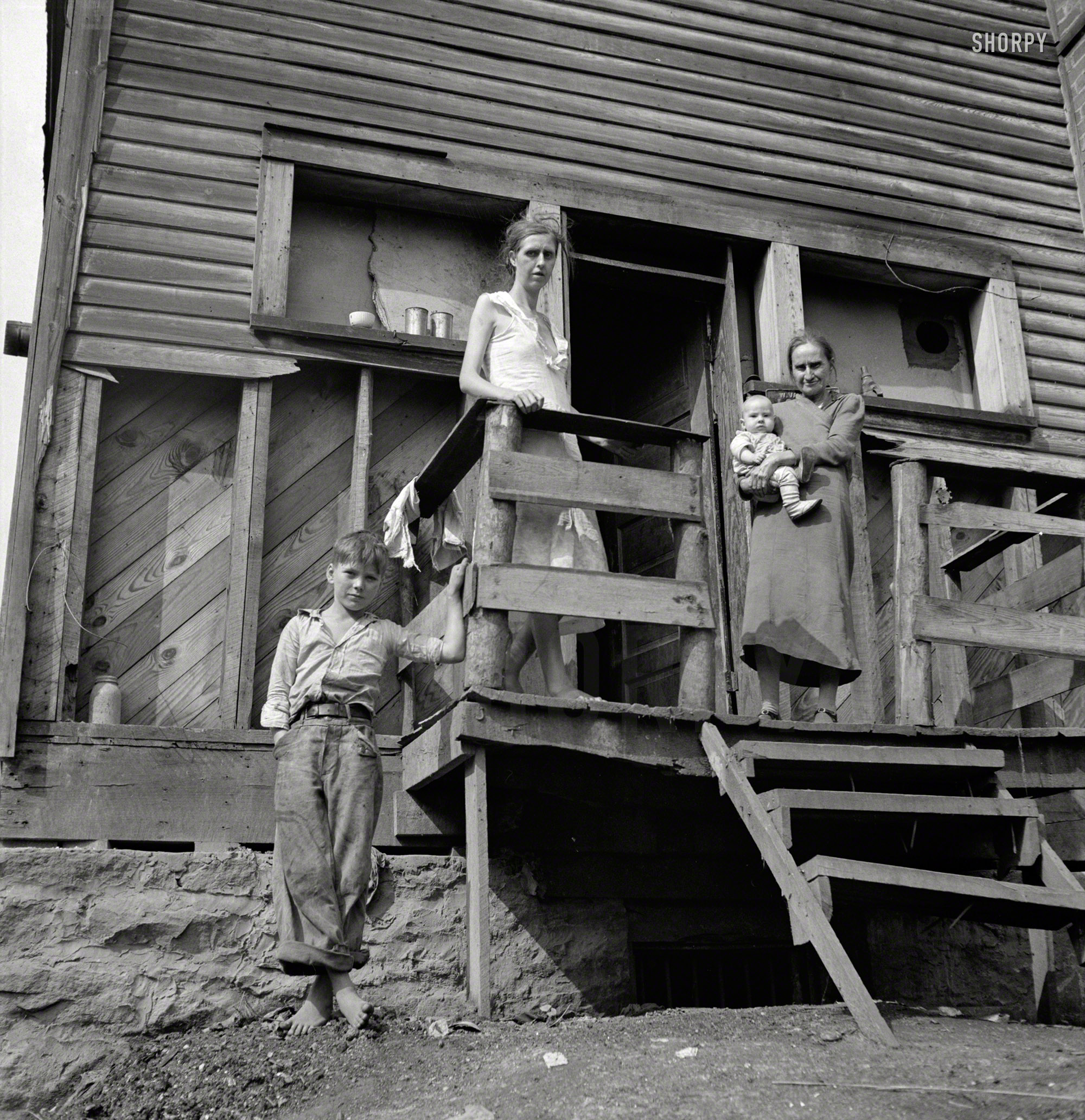September 1938.  "Wife of unemployed coal miner, suffering from T.B., with her mother and children. Family living in old company store. Abandoned mining town of Marine, West Virginia." Photo by Marion Post Wolcott. View full size.
