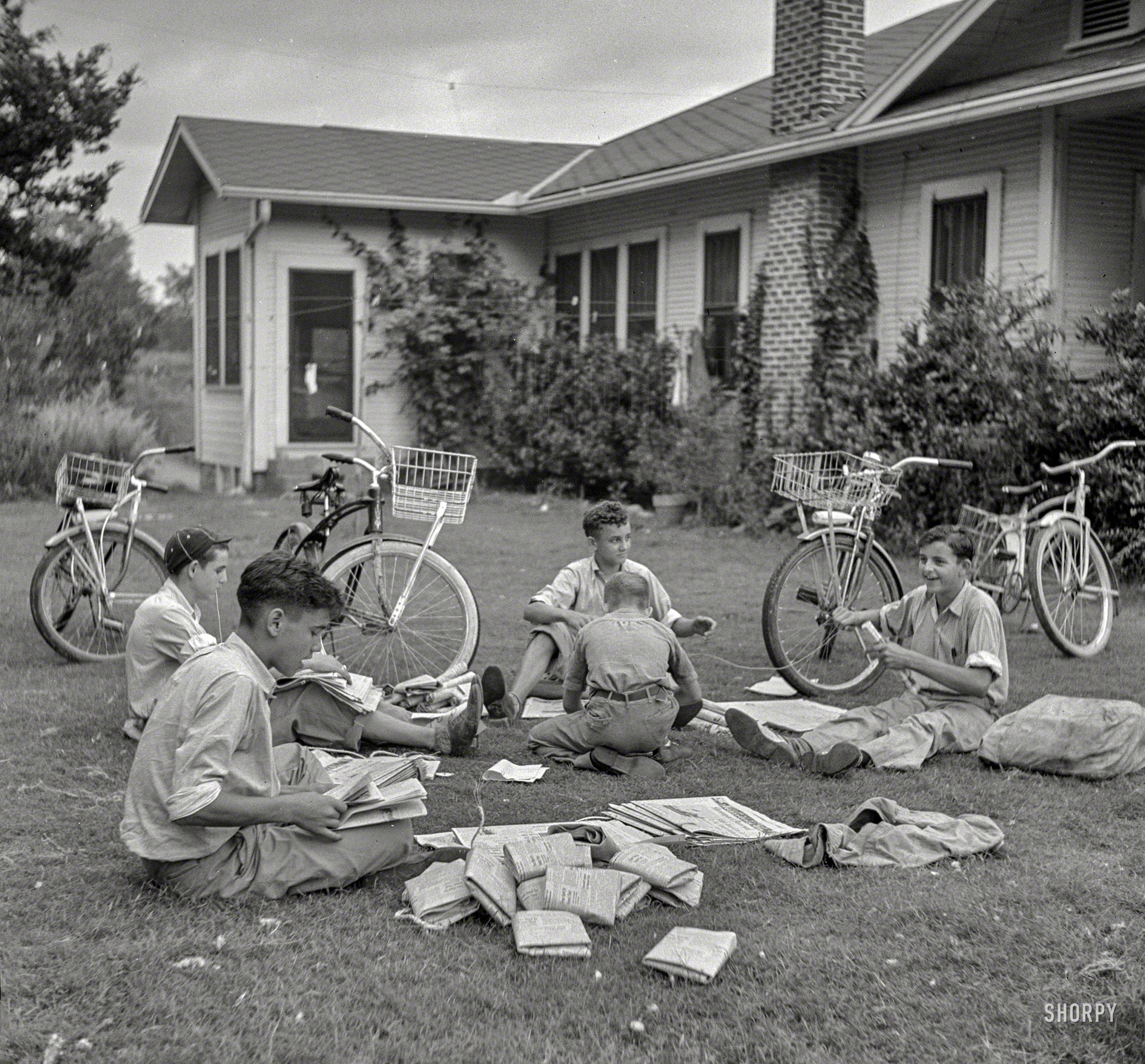 July 1940. "Boys in Natchitoches, Louisiana, folding papers before delivering them in the afternoon." Photo by Marion Post Wolcott. View full size.