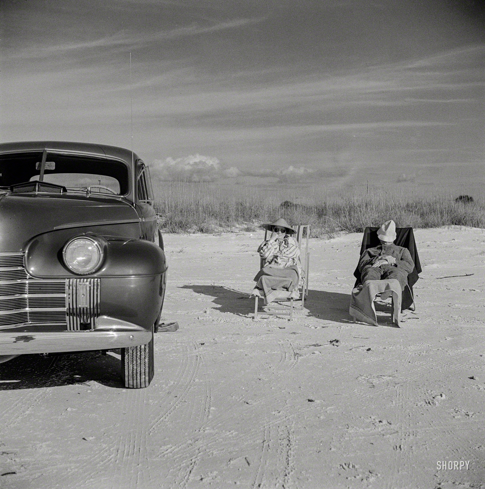 January 1941. "Guests of Sarasota, Fla., trailer park enjoying the sun and sea breeze at the beach." Photo by Marion Post Wolcott. View full size.