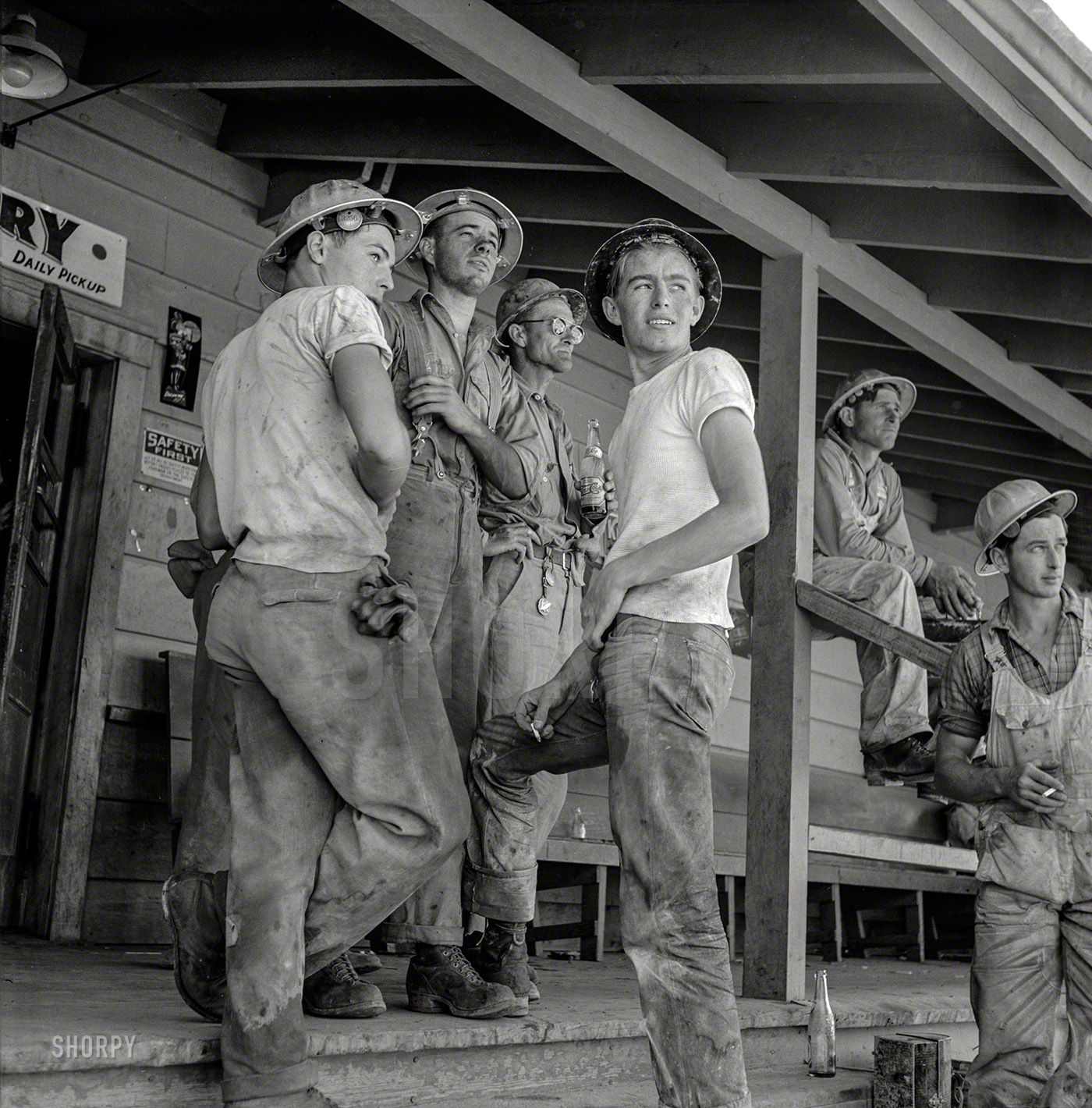 June 1942. "Shasta Dam, Shasta County, California. Workmen on porch of com&shy;mis&shy;sary." Photo by Russell Lee for the Office of War Information. View full size.