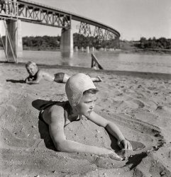June 1942. "Redding, California. Youngsters at the beach on the Sacramento River." Kids these days! Nitrate negative by Russell Lee for the Office of War Information. View full size.
Sorry KidsBut in this photo the bridge wins!
Good old daysBack when bridges had visible steel.
Kids Today 2013Forgive my quick and extremely sloppy photo manipulation, but I had to slap something together before I hit the hay for the night. :)
Not so sandy any moreView Larger Map
Sacramento RiverExciting to see my neck of the woods!  The still impressive railroad trestle, Southern Pacific at the time, now Union Pacific was new trackage permanently rerouted due to Shasta Dam construction (1938-1945) on the Sacramento River.  The old right of way along the river is now a path from Redding CA to the dam. The kids are in an area that was a popular swimming spot, the beach at various times was imported as the area is more gravel, rock and clay than sand.
Hair pullingUgh! I HATED those rubber bathing caps!  They were hot and they stuck to your hair and pulled it getting it on and taking it off!
(The Gallery, Boats & Bridges, Kids, Russell Lee, Swimming)