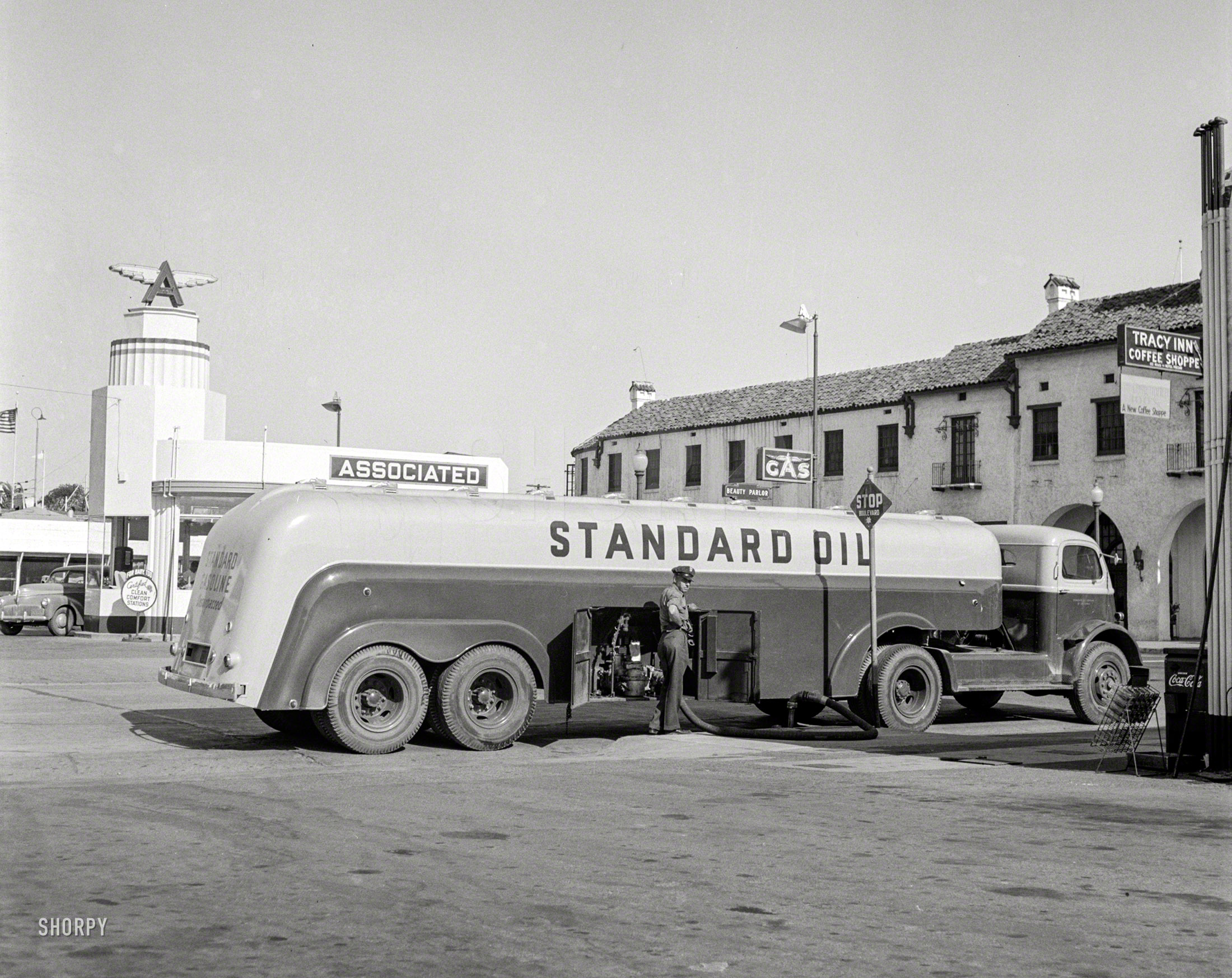 June 1942. "Tracy, California. Tank truck delivering gasoline to a filling station." Photo by Russell Lee for the Office of War Information. View full size.