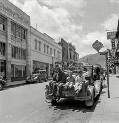 June 1942. "Yreka, California, seat of a county rich in mineral deposits." But poor in car seats. Photo by Russell  Lee, Office of War Information. View full size.
Largely intactUsing Google Street View: this photo was shot from the intersection of Miner St and (North) Broadway -- looking westward along Miner Street. The building to the left of the hotel is gone; replaced by a corner parking lot -- with a historic marker.
View Larger Map
Mom &amp; DadDon't seem exactly thrilled to be the photographer's subjects.
A New BroomNice to see some things haven't changed much in 70 years.  
Same age...I think I am about the same age as the kid on the right...riding in pickup "beds" at that time was fun...before it was a "no no"...
The thanks I getFor getting you through the depression without starving, you put me in the back of the truck with my bratty grand kids.
(The Gallery, Cars, Trucks, Buses, Kids, Mining, Russell Lee)