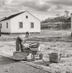 October 1941. Radford, Virginia. "Sunset Village, FSA project for defense workers in Hercules powder plant. Individual homes on land leased from nearby farmers. Son of defense worker gathering scrap lumber." Photo by Marion Post Wolcott, Farm Security Admin. View full size.