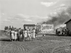 January 1939. "Lake Harbor, Florida. Negro agricultural laborers watching one of their houses burn to the ground. All they have left is piled on the ground." Medium format acetate negative by Marion Post Wolcott for the Farm Security Administration. View full size.
