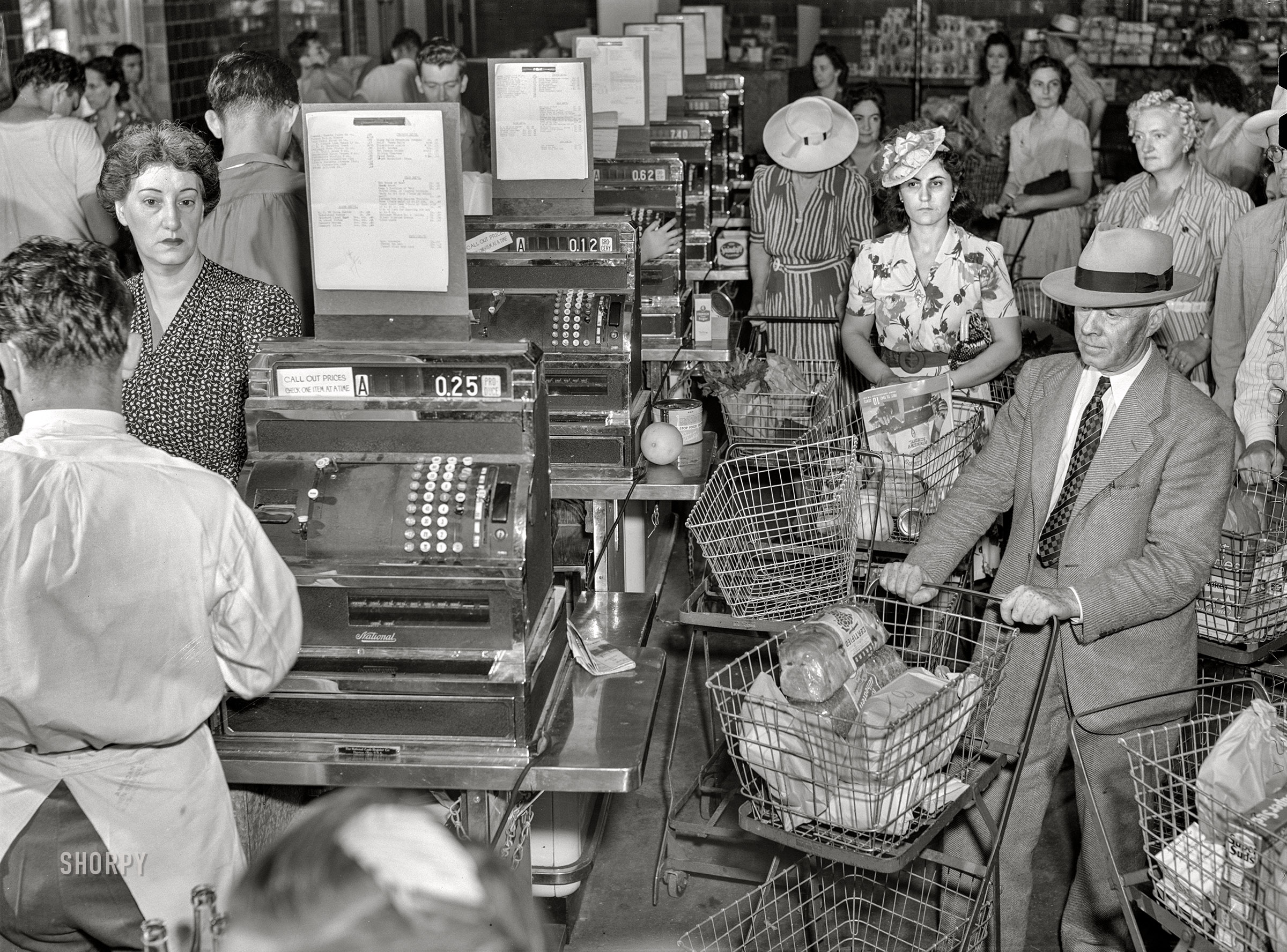 June-July 1942. Washington, D.C. "Cashiers checking out customer purchases with Ration Book No. 1 at the Giant Food shopping center on Wisconsin Avenue. Giant Food Store is a self-service market chain handling all types and many varieties of food and household appliances." Acetate negative by Marjory Collins for the Farm Security Administration. View full size.