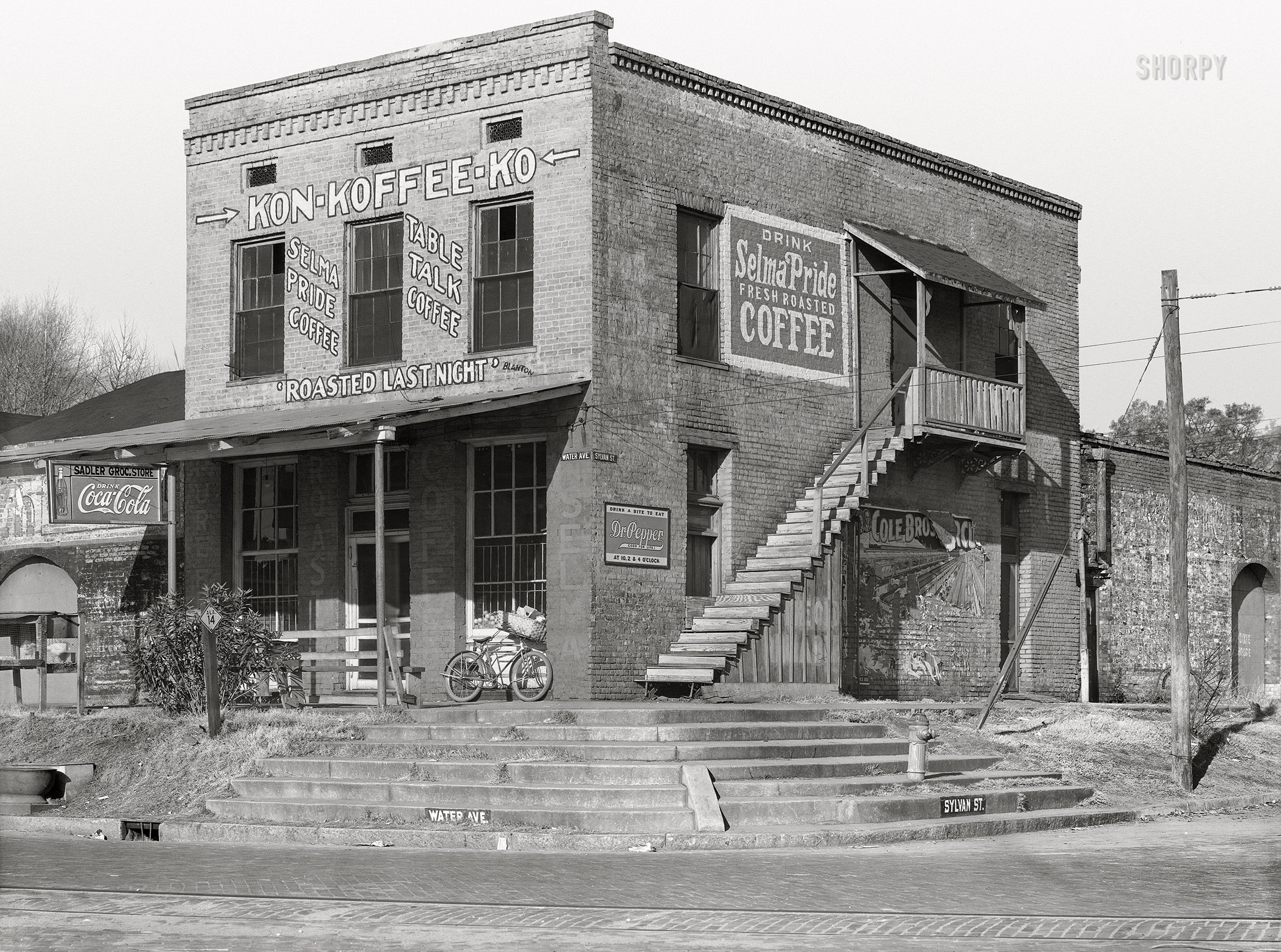 December 1935. "Coffee house in Selma, Alabama." The Sadler Grocery Store, purveyor of Kon-Koffee-Kompany's Table Talk and Selma Pride ("Roasted Last Night") as well as Coca-Cola and Dr. Pepper. Nitrate negative by Walker Evans for the Resettlement Admin. View full size.