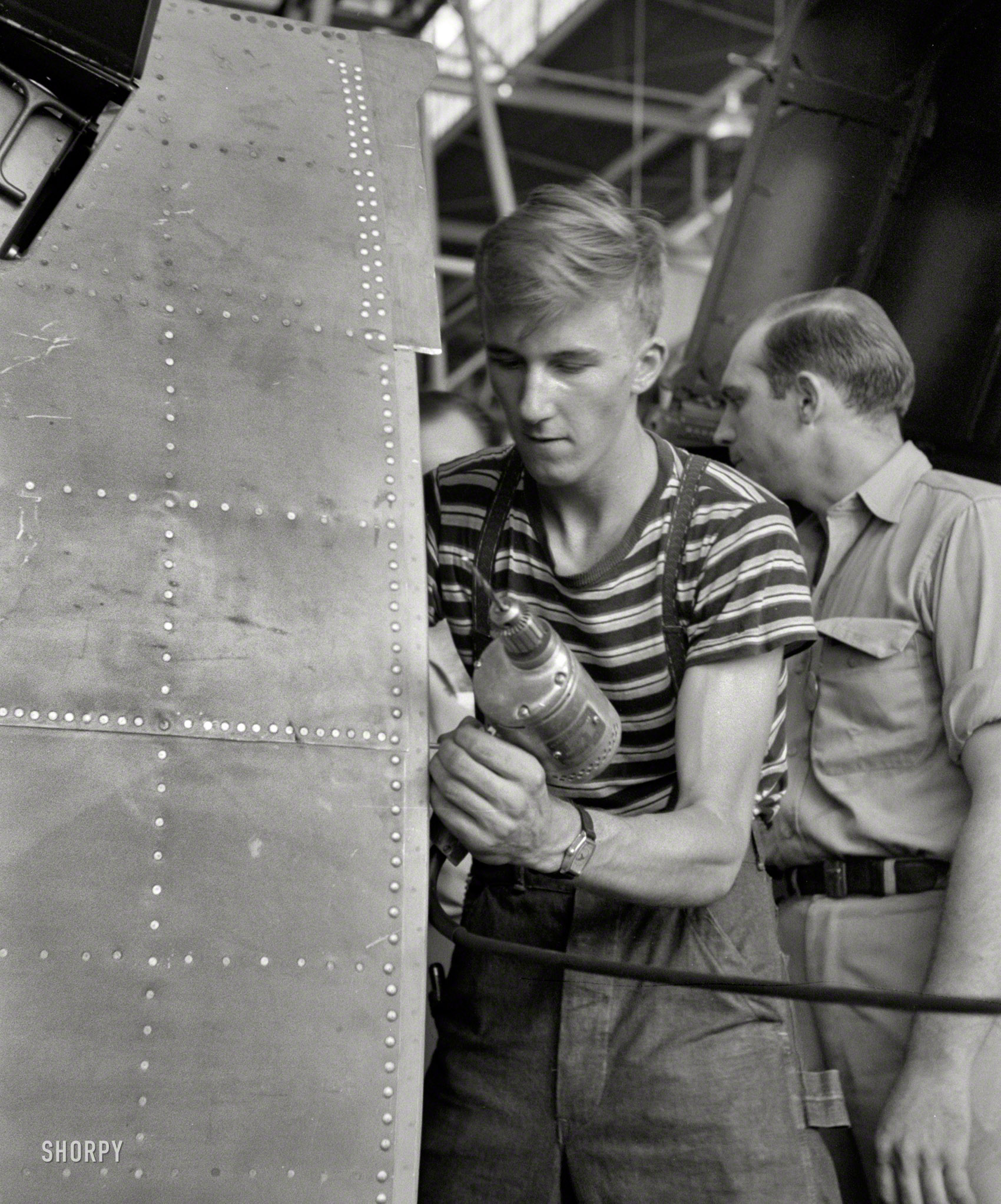 August 1942. "Vultee Aircraft Co., Nashville. Using an electric drill on a fuselage in a sub-assembly section." Another boy putting an airplane together during WW2. Photo by Jack Delano for the Office of War Information. View full size.