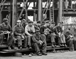 May 1943. "Bethlehem-Fairfield Shipyards, Baltimore, Maryland. Portraits of the workers who turn out 'Liberty' ship cargo transports, during lunch hour or on rest period." 4x5 inch acetate negative by Arthur Siegel for the Office of War Information. View full size.
Juan de la cruz is awesomeThe photo with "What is being said"? is different from the original "Let's Do Launch". Either Mr. de la Cruz has astounding Photoshop skills or it is the second in a series of pix.    Either way it is a personality plus photo.
[I added the photo to show what they were laughing at. - Dave]
Short-lived but crucialThe Birmingham-Fairfield Shipyard existed for less than five years. It was one of two yards (the other in Portland, Oregon) constructed under the 1941 Emergency Shipbuilding Program. The emergency? Even though the U.S. was still officially neutral, it had to react to the severe losses of the British Merchant Navy in the Battle of the Atlantic.
The Baltimore yard built Liberty Ships, eventually 384 of them, along with LSTs (Landing Ship, Tanks) and Victory ships.
What is being saidWould love to know what is causing all the smiles.  What is the conversation.
If I had the editing skills, I'd add balloons to each of people with, starting from right to left:  "Say what?" "Can't be true!" "He really did that?"  "Yup, I saw him -- "
And then I run out of conversation.  Someone else, with better imagination, can carry on.

Dave - Thank you for adding it.  Wish I could take credit for it, but I can't.  It is as fun a photo as the original.  Lots of smiles.  And I really wish I could hear the comments!
Brown bagsFrom what I can see, they all brown bag their lunch.  I wonder why none of them has a black, domed top, metal lunchbox with a handle?
[Because when a metal lunchbox falls on your head from 50 feet up, it hurts. - Dave]
Point taken.  The other observation I have is about the guy sitting fourth from the right, including the man sitting on the bottom step.  I'm pretty sure he was a football lineman.  He's a big guy and he's wearing what appears to be a varsity letter on his sweater.
Waxed paperWhen I was a kid we didn't have plastic sandwich bags. A sandwich wrapped in wax paper worked just fine. At the lunch table, I could lay it flat for a clean place to lay my lunch out on.  Occasionally, I'll still wrap a sandwich in wax paper.
The S.S. John W. Brownwas assembled at the Baltimore shipyard in 1942, and is one of two surviving fully operational Liberty Ships preserved in the United States. It is docked in Baltimore, and open for tours and living history cruises.
https://www.ssjohnwbrown.org/
Looks like Central CastingEach one of these guys looks like some character actor. Especially the fellow in the white sweater, I'm sure I've seen him in a Bowery Boys picture.
Good bunch of guysThere's lots of nice body language in this shot. I especially like the fellow, lower center, leaning back into the legs of the guy behind him, who is gesturing with a touch to the shoulder. And, of course, they are of different races -- in a time that racial segregation was widely legal and widely practiced.
VarietyThat's quite a collection of headgear. The man with the bill-less cap probably is wearing it backward, not because it was the style but possibly because he wears a welder's mask when he's working. Today you would probably see uniform OSHA-approved hard hats.
And you wouldn't see any cable-knit sweaters.
(The Gallery, Arthur Siegel, Baltimore, Boats & Bridges, WW2)