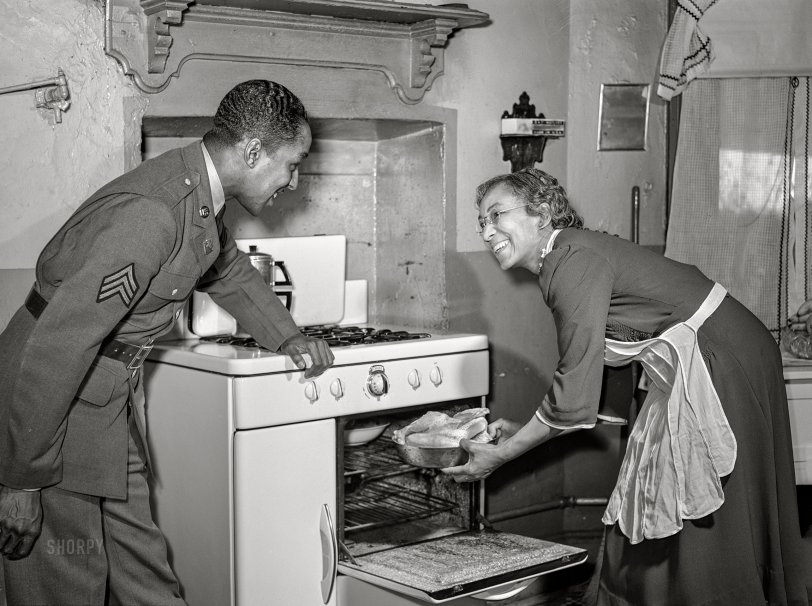 March 1942. "Baltimore, Maryland. Sergeant Franklin Williams, home on leave from Army duty at Fort Bragg, watching his mother put chicken into the oven." Specifically, an Oriole range made by the Standard Gas Equipment Corporation of Baltimore. Medium format acetate negative by Arthur Rothstein for the Office of War Information. View full size.