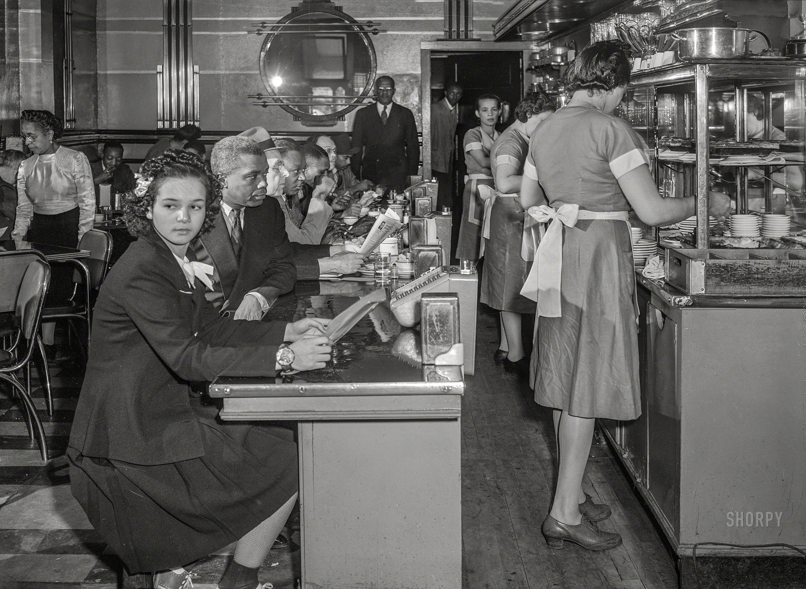April 1942. "In the Perfect Eat Shoppe, a restaurant on 47th Street near Chicago's South Park; Mr. and Mrs. Earl Morris (standing at rear and left), proprietors." Photo by Jack Delano for the Office of War Information. View full size.