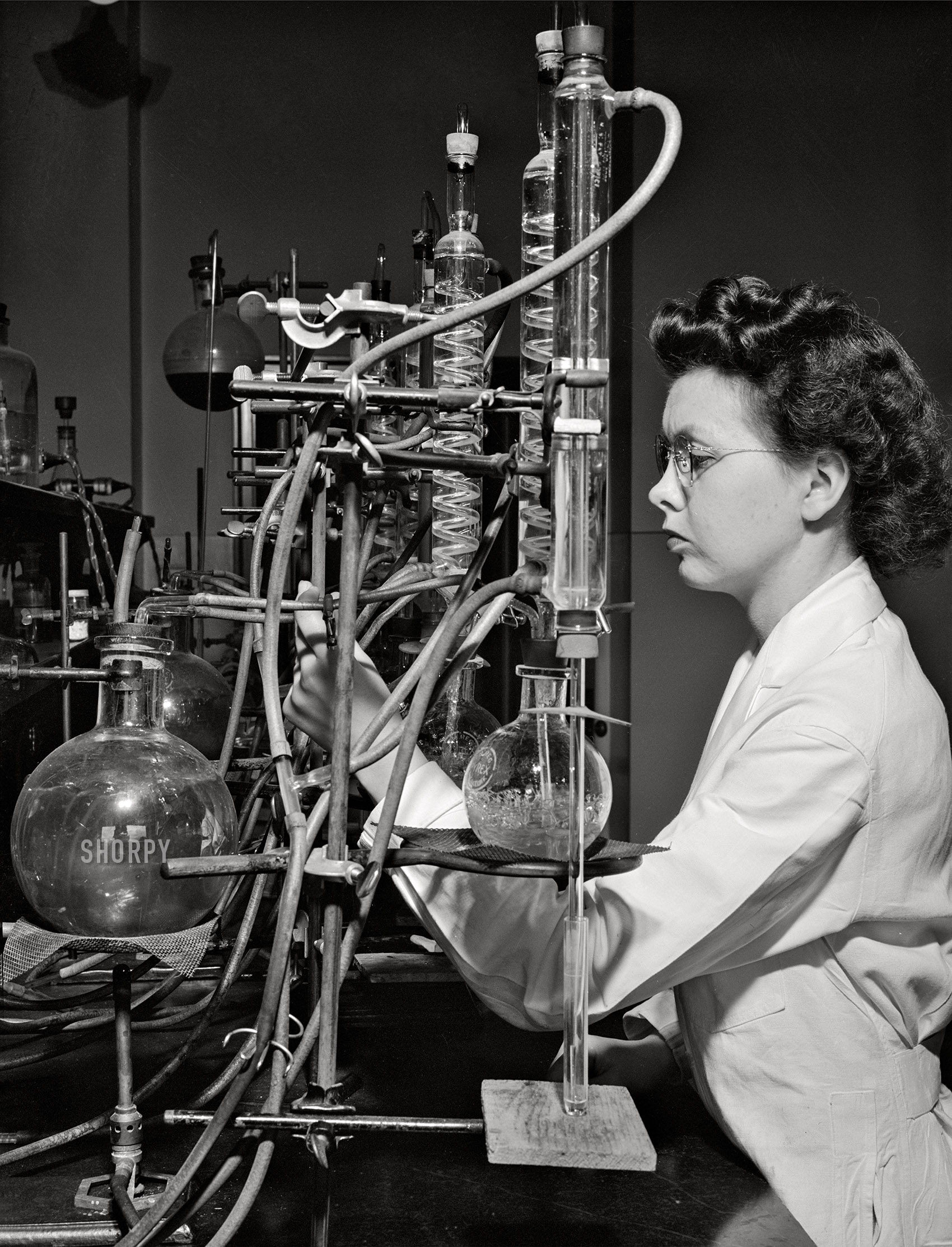 May 1942. "Iowa State College. Ames, Iowa. Miss Jeanne Dougherty, graduate in Bacteriology, working in the laboratory in the Dairy Industry Department. She is conducting experiments on the effects of acids on flavor of butter." Acetate negative by Jack Delano. View full size.