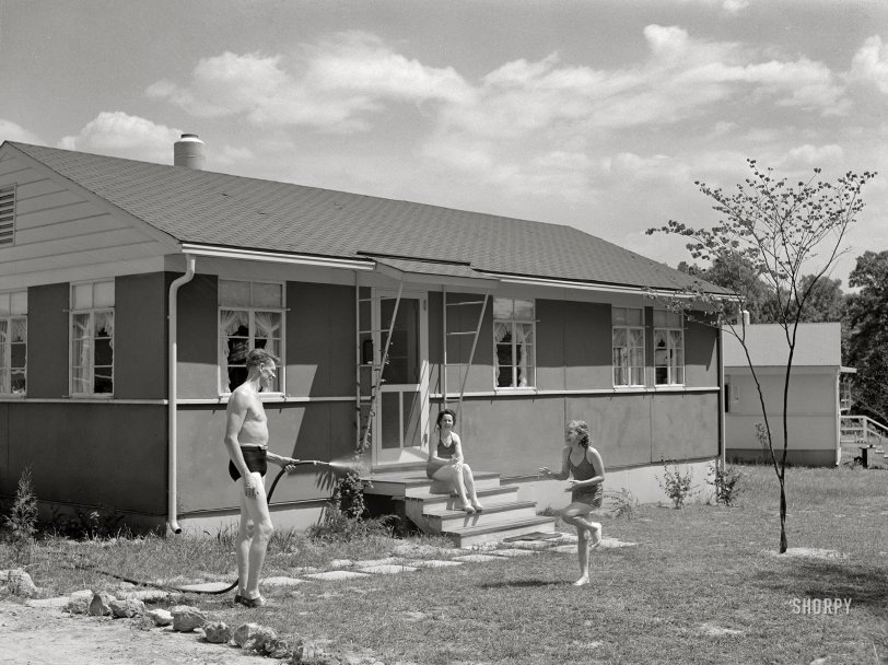 June 1942. "Sheffield, Alabama (Tennessee Valley Authority). Housing for defense workers. Kenneth Hall gives daughter Peggy a shower with garden hose in front of their TVA defense home." The nice people last seen here. Acetate negative by Arthur Rothstein. View full size.
