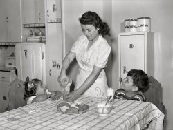 June 1942. "Brooklyn, New York. Red Hook housing development. Mrs. James Caputo in the modern kitchen of her apartment, pouring milk for Annette and Jimmy. The children drink more than a quart apiece daily." Acetate negative by Arthur Rothstein. View full size.
