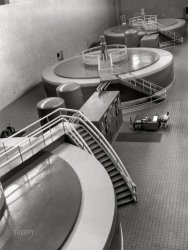 August 1942. "Tennessee Valley Authority. Generator hall of the powerhouse at Chickamauga Dam. Located near Chattanooga, 471 miles above the mouth of the Tennessee River, the dam has an authorized power installation of 81,000 kilowatts, which can be increased to a possible ultimate of 108,000 kw. The reservoir at the dam adds 377,000 acre-feet of water to controlled storage on the Tennessee River system. The power that goes out over its 154,000 volt transmission line serves many useful domestic, agricultural and industrial uses." Acetate negative by Jack Delano for the U.S. Foreign Information Service. View full size.
