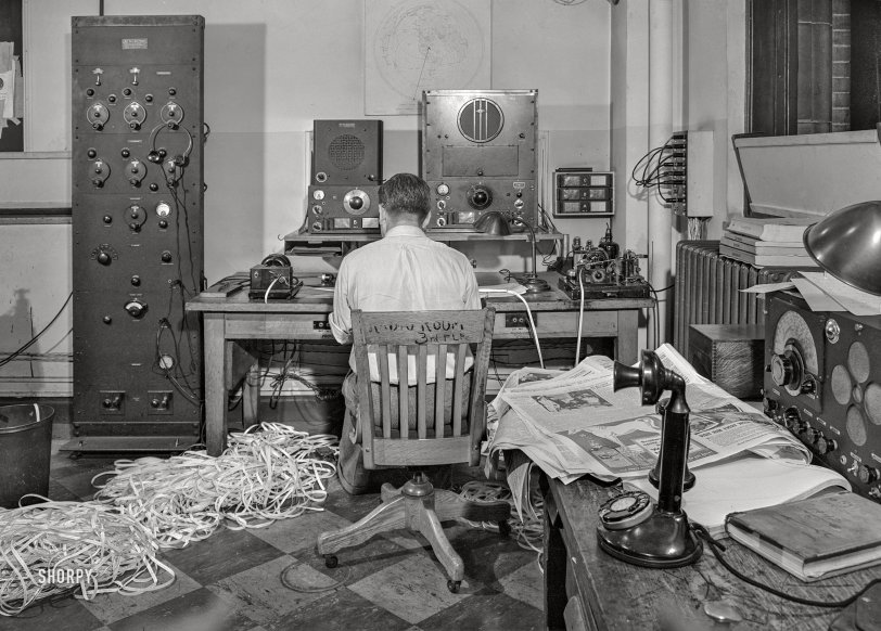 September 3, 1942. "New York, New York. Radio room of the New York Times newspaper. The Times listening post, between 10 pm and midnight, between first and second editions. The operator is listening to Axis news (propaganda) broadcast. Paper in foreground has been examined to see what has already been covered in last edition of paper. Operator reports and gives new angles to city editor. Messages are recorded on paper tape in international Morse code." Acetate negative by Marjory Collins for the Office of War Information. View full size.