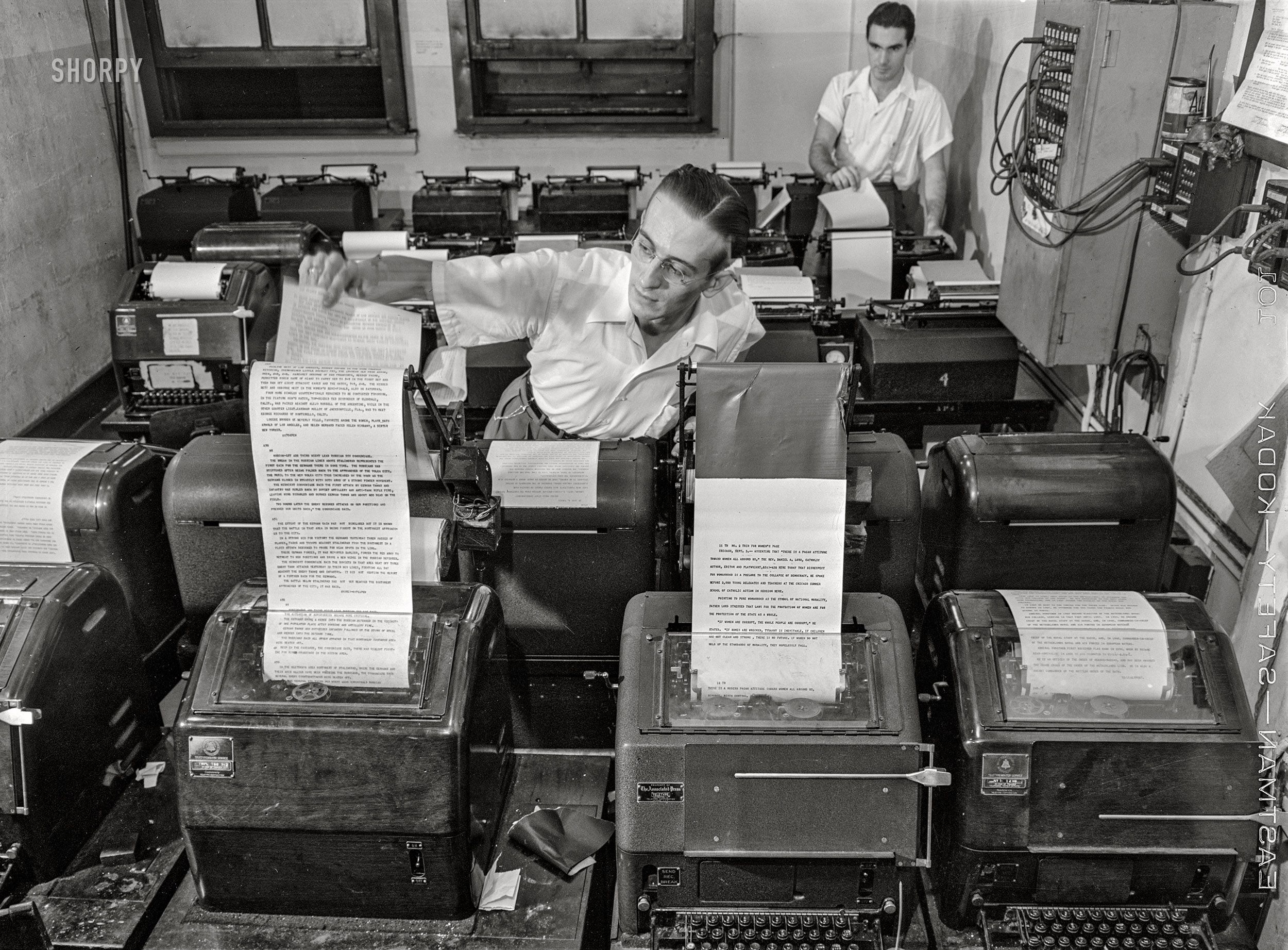 September 3, 1942. "New York, New York. Wire room of the New York Times newspaper. Copy boy about to tear off dispatch from the Associated Press wire." Medium format acetate negative by Marjory Collins for the Office of War Information. View full size.
