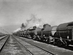 November 1942. "Chicago, Illinois. An oil train from the Southwest leaves an Illinois Central railyard for the Pennsylvania Rail Road to be sent on to the East." Medium format acetate negative by Jack Delano for the Office of War Information. View full size.