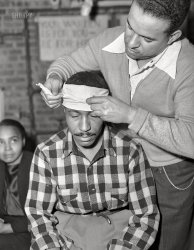 November 1942. Washington, D.C. "First aid class of the air raid warden unit in the Southwest area. Mr. Elmer House, instructor, demonstrating the head bandage." Self-portrait by Gordon Parks for the Office of War Information. 4x5 inch acetate negative. View full size.