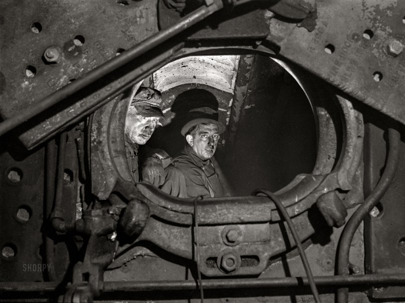 December 1942. "Chicago, Illinois. Boiler makers inside the firebox of a locomotive on which they have been working in the roundhouse at a yard of the Chicago and North Western Railroad." Acetate negative by Jack Delano for the Office of War Information. View full size.