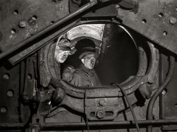 December 1942. "Chicago, Illinois. Boiler makers inside the firebox of a locomotive on which they have been working in the roundhouse at a yard of the Chicago and North Western Railroad." Acetate negative by Jack Delano for the Office of War Information. View full size.
BOILER UP!Thank you, Dave.
Zebra Man
Purdue University
Class of '88
Re: BOILER UP!My dad was also Purdue, Class of '32 (delayed due to WWI).
A few years later worked for Baldwin as a delivery agent, deadheading in the cab as new locos were rolled out to customers.
Pretty amazing Century, over all!
Dangerous JobMy father worked in the railyards back in the Thirties. He used to say that a lot of the guys working in the boilers were gone by the 1950s. Asbestos got them, he'd say. Who knew?
(The Gallery, Chicago, Jack Delano, Railroads)