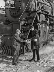 January 1943. "Conductor handling engineer copy of train orders before a Chicago and North Western freight pulls out of Chicago for Clinton, Iowa. Since the track between those points is under automatic train control, the engineer hands the conductor the key to the automatic train control lock of the engine. The conductor will keep the key in the caboose until the train arrives at its destination." Acetate negative by Jack Delano, Office of War Information. View full size.