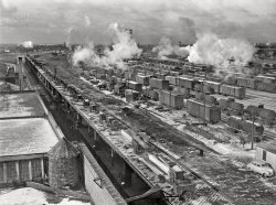 January 1943. Riverdale, Illinois. "Blue Island Yard of the Indiana Harbor Belt Railroad with view of the icing platform." Photo by Jack Delano, Office of War Information. View full size.
Indiana Harbor Belt abidesThe Blue Island Yard seems to be pretty active still:

Icing Platform?Have not before heard of such a thing.
Yes, IcingBefore mechanical refrigeration was developed, railroad refrigerator cars were kept cold by ice in bins at the ends of the cars. (Remember the icebox in the home?) The bins were filled through hatches in the roof of the cars, usually at the ends. Icing platforms were a little taller than the refrigerator cars, arranged to ease getting ice into the bins. The boards you see were probably used to make temporary bridges to the cars, including to reach to the far side hatches.
Freeze FrameThe Wikipedia article on refrigerator car had a photo of the icing platform in use, possibly from the same Jack Delano series. I was surprised that mechanical refrigeration for rail cars didn't catch on until after WWII.

(The Gallery, Jack Delano, Railroads)