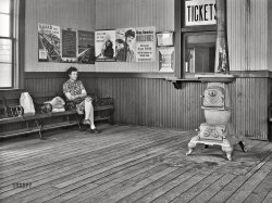 April 1943. "San Augustine, Texas. Story of a small town. The waiting room in the railroad station." Acetate negative by John Vachon for the Office of War Information. View full size.
$100 RewardAs best I can read the sign, the city of San Augustine is offering a $100 reward ($1,805 today) for information leading to the arrest and conviction of anyone guilty of arson.  It's signed by the mayor of San Augustine.  Dave -- how close did I get?
San Augustine is in East Texas, home of large tracts of piney woods.  Arson is serious business there.
Click to embiggen

If I were a blindfolded time traveler ... and placed in this station, I'd be able to identify where I was by the way it smelled: a mixture of coal smoke, stale cigar smoke, and the faint aroma of a spittoon in the corner. In the late 1940s Midwest, I remember taking the train with my grandmother 15 miles into the local "big town" (population 20,000) for a day of shopping. Every small town had a train station. Gone forever, sadly.
What?!?"Are you telling me there is no separate ladies waiting room?"
Possibly still there? This old building on Google Maps has small-town-train-station characteristics, anyway.
Oh that stove!My maternal grandparents had a stove just like that in Crosby, Mississippi -- it did a fine job keeping the farmhouse warm and even toasty. I was too young to have to chop the wood, but loved making a fire in the mornings.
That waiting room is about the size of their entire house, or maybe half the size.
Memories ...
Smoke Consumer Also CooksIf you have one of these buried in your barn, pull it out and eBay it. Depending on condition and age it could be worth anywhere from $1,000 to $4,250.
On top were plates to keep your coffee hot and maybe toast that sandwich Mom packed for you.
(The Gallery, John Vachon, Railroads, Small Towns, WW2)