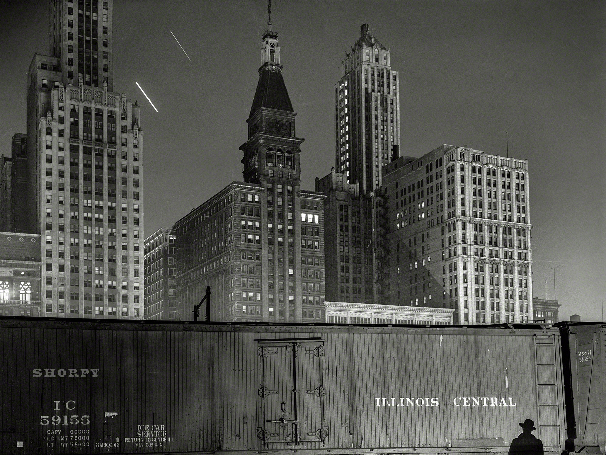 May 1943. Chicago. "Special agent making his rounds at night at the South Water Street freight terminal of the Illinois Central Railroad." Medium-format negative by Jack Delano for the Office of War Information. View full size.