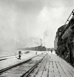 January 1943. "Freight operations on the Indiana Harbor Belt railroad between Chicago and Hammond, Indiana. The train pulls out of the Chicago &amp; North Western yard." Photo by Jack Delano, Office of War Information. View full size.
This would bethe Proviso Yard of the C &amp; NW, located about fourteen miles directly west of the Loop between Bellwood and Stone Park.  When I was a kid I'd ride my three-speed Hercules north up Westchester Boulevard and Bellwood Avenue to where the latter dead-ended at the yard.  Then I'd wander around within about the largest rail yard in the region watching mammoth freight trains being assembled.  Only in retrospect do I realize how dangerous that was.  The IHB's main line passed by a few blocks from my home, and I clearly remember steam engines of the Milwaukee Road, which had trackage rights on the IHB, chugging away pulling freight (usually northbound) amid heavy coal smoke with screeching whistles, in the early 1950s and maybe later.
(The Gallery, Jack Delano, Railroads)