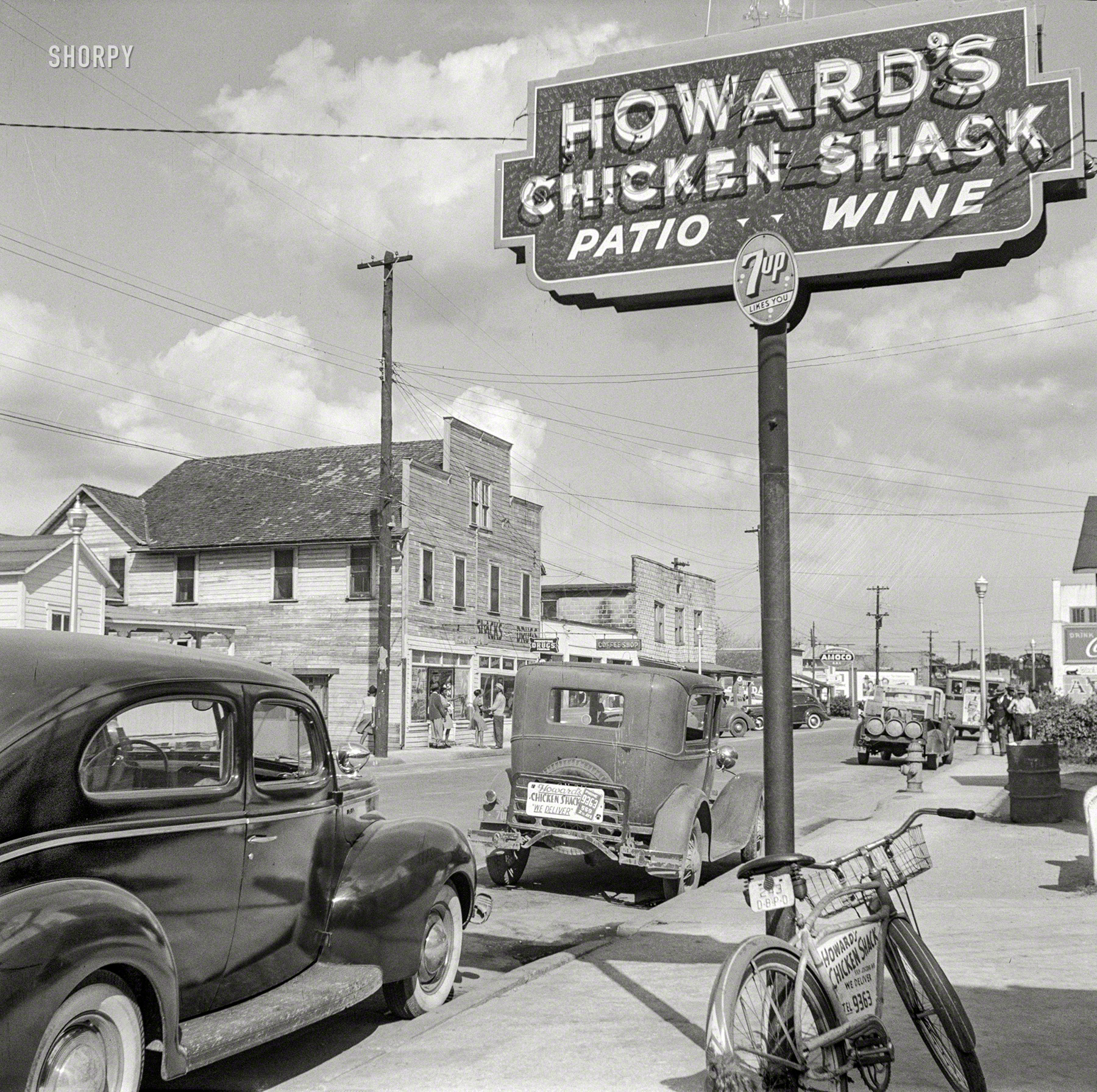 February 1943. "Daytona Beach, Florida. Street scene." Howard's Chicken Shack -- we're going to phone 9363 and see if they can deliver to 2016. Medium format negative by Gordon Parks for the Office of War Information. View full size.