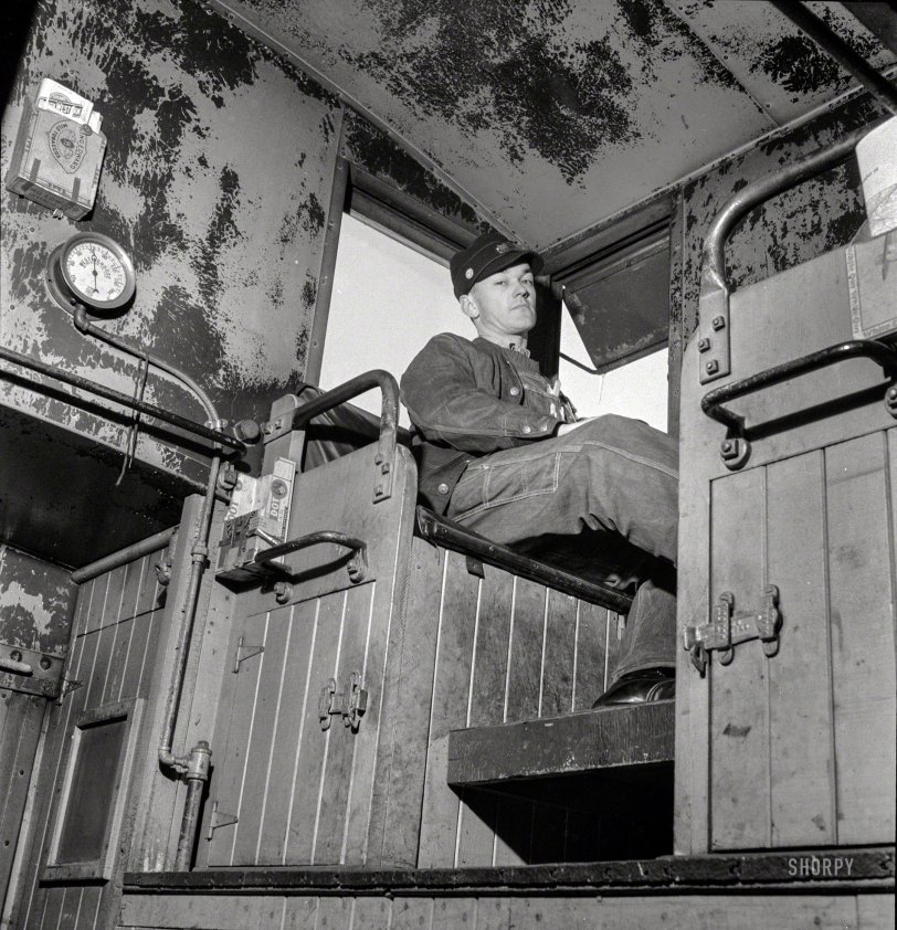 March 1943. "Walter V. Dew, rear brakeman, on the Atchison, Topeka &amp; Santa Fe between Chicago and Chillicothe, Illinois, watching the train from the cupola." Photo by Jack Delano for the Office of War Information. View full size.
