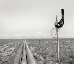 March 1943. "Willard, New Mexico. Santa Fe flagman walks back to signal any oncoming trains during a stop for water between Vaughn and Belen." Photo by Jack Delano for the Office of War Information. View full size.