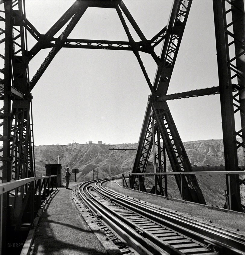 March 1943. "Topock, Arizona (vicinity). Military sentry stationed at a bridge over the Colorado River along the Santa Fe Railroad between Seligman, Arizona, and Needles, California." Photo by Jack Delano. View full size.
