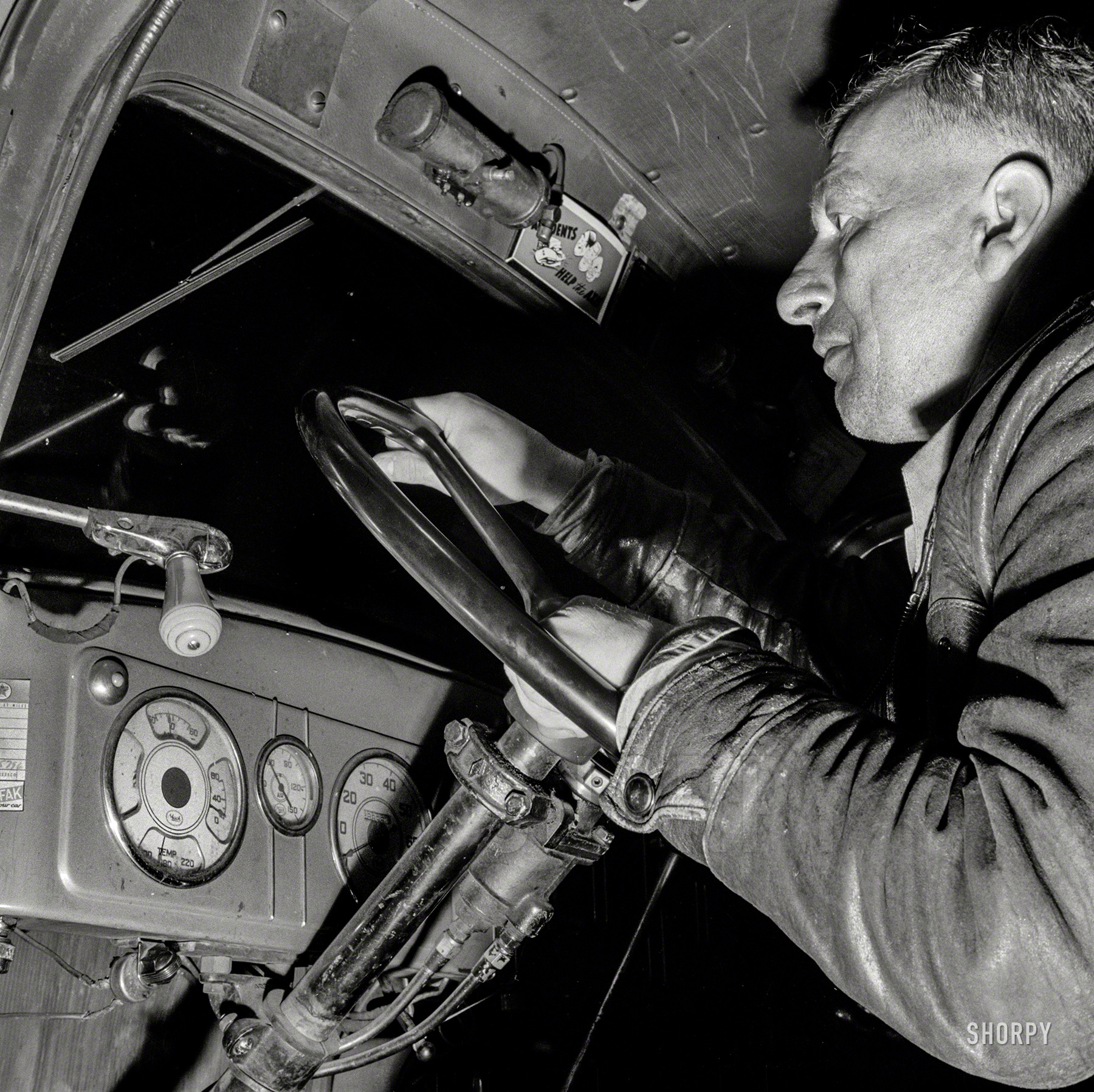 March 1943. Pearlington, Mississippi (vicinity). "James Hall, truck driver, en route to New Orleans on U.S. Highway 90." Header placard: "Accidents Help the Axis." Photo by John Vachon for the Office of War Information. View full size.