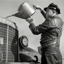 March 1943. "Melvin Cash, truck driver, putting water in his radiator along U.S. Highway 29 in North Carolina en route to Charlotte." Medium format negative by John Vachon for the Office of War Information. View full size.
Easy Peasy Nice and EasyI'll take the jacket, the hat and the water bucket.   I'd take the truck too but parking could be a challenge.   I love SHORPY -- it never fails to deliver.
Truck IDBrown; in house make of Associated Transport.
[The tractor is a circa 1938 Corbitt in Horton Trucking livery. Some of these were rebadged as Browns after Horton entered into the Associated Transport merger. - Dave]
Sealed beam conversion?Hayslip, looking at the size of the headlight buckets versus the headlights, I'm wondering if it has been fitted with a sealed beam conversion.  One big advantage that came with the advent of sealed beams was that the lamps were a universal 7-inch size that would fit anything.  It was much easier to replace the lamp after it burned out, and replacing one after taking a hit from a stone meant you didn't have to try to find parts specific to your vehicle - especially important for over-the-road trucks.
The REAL movers and shakersThis comment may seem off-topic, but I'd like to acknowledge all the truckers and railroad workers that often provided a bright spot to the day for many youngsters, me included, at least in the 1940's and 50's since we walked everywhere including to school, church, movies, the park, etc. It was such a kick for a kid to see a big rig coming down the road and know that if he just put up his arm and pretended to pull a rope, that the congenial trucker would blast on his air horn just for us.  Likewise, if a train was passing by and we could see the engineer or the caboose man, they would wave and blow their whistle and make one feel important. Yes, I was a sometimes lonely, small town kid, usually walking alone everywhere, but these men made me feel like I had some influence in the world. It was a feeling of mutual respect on both sides and I salute and thank them all for taking the time to acknowledge the requests of all the powerless children everywhere who enjoyed immensely causing the instant reaction from the vehicle's operator.  I know the work of truckers and railroaders is grueling and often taken for granted but they made the day for many kids and brought everything people needed to remote villages and towns across the country and they still do.  Thanks guys.
(The Gallery, Cars, Trucks, Buses, John Vachon)