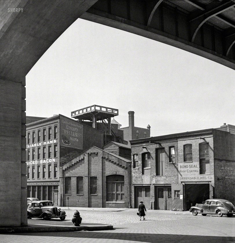 April 1943. "Baltimore, Maryland. Street under viaduct." Where the manufacturing is Dependable and the hams are Reliable. Photo by Marjory Collins for the Office of War Information. View full size.

