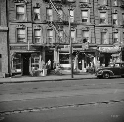 May 1943. "New York. A tenement house in Harlem." Note the sign advising of COVER. Photo by Gordon Parks, Office of War Information. View full size.