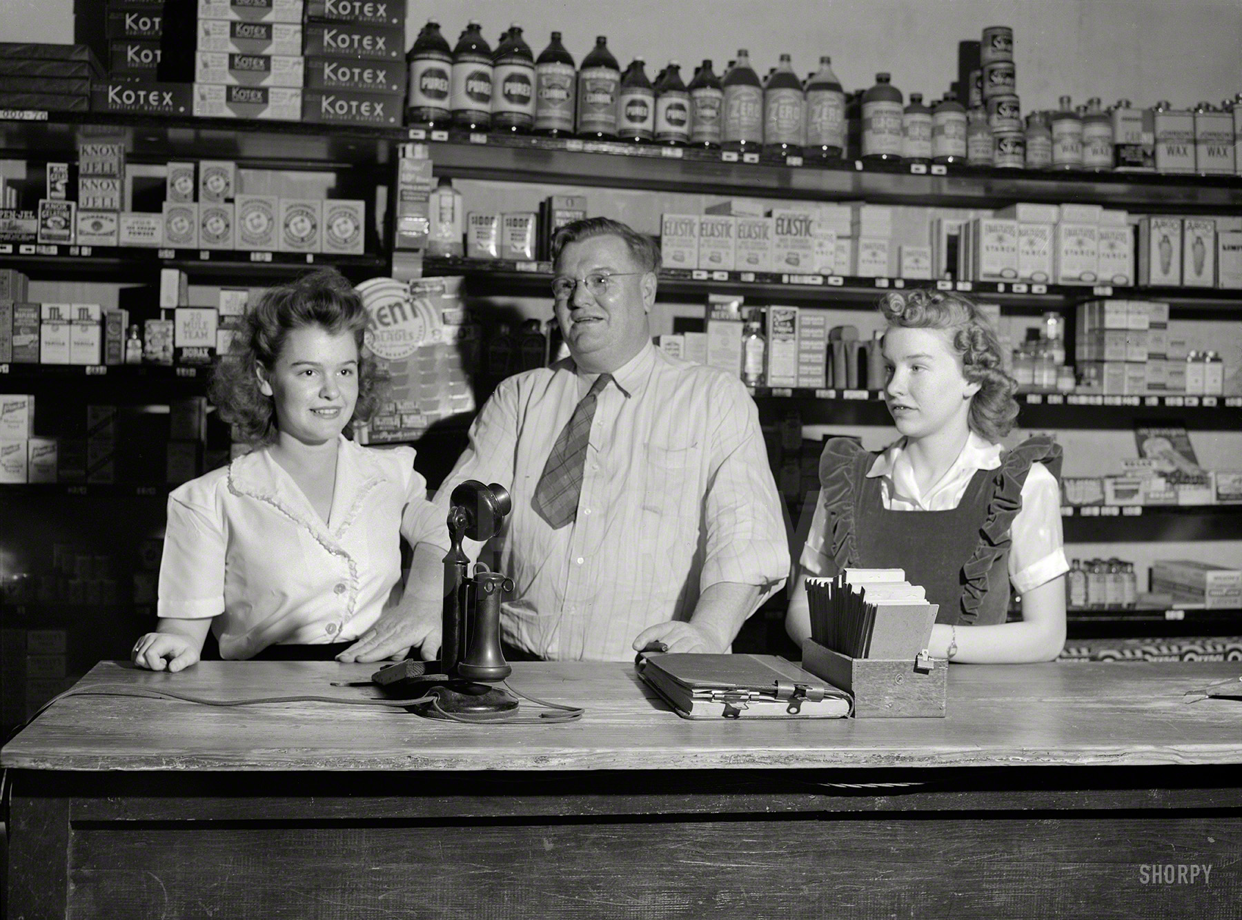 April 1943. "San Augustine, Texas. Clyde Smith, grocer, with his two daughters." Papa gets sartorial points for the ironic necktie. Medium format acetate negative by John Vachon for the Office of War Information. View full size.