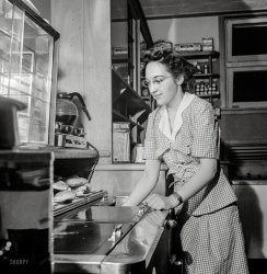 June 1943. "Arlington, Virginia. Girl getting food in the service shop at Idaho Hall, Arlington Farms, a residence for women who work for the U.S. government for the duration of the war. The shop help is run on a self-service basis." Photo by Esther Bubley for the Office of War Information. View full size.