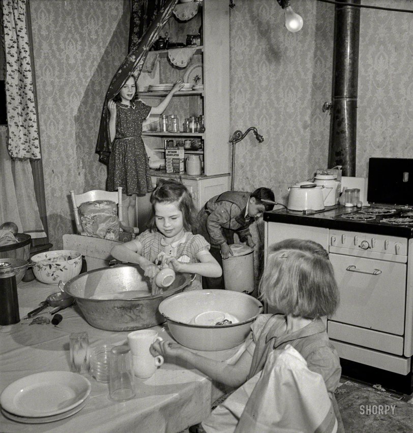 May 1943. Buffalo, New York. "Patsy Grimm helping with housework. Their mother, a 26-year-old widow, is a crane operator at Pratt and Letchworth." Photo by Marjory Collins for the Office of War Information. View full size.
